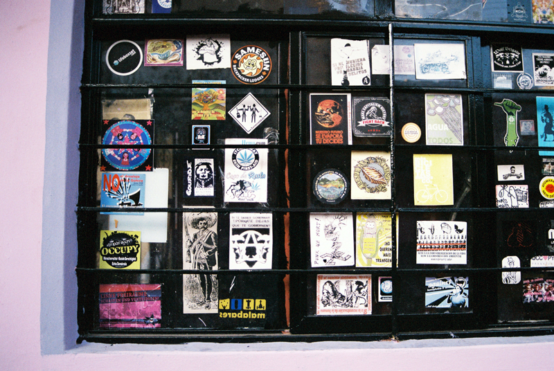 Ephemera and activism on the windows of the kitchen of Casa Libertad.