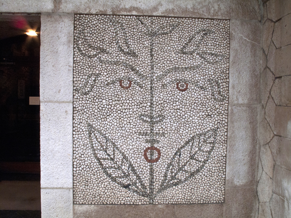 A faun man in Cocteau's pebble mosaic outside the Bastion Museum.